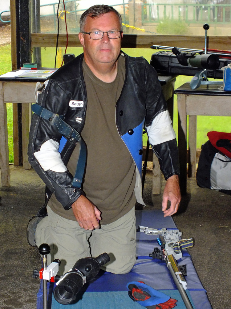 Photograph shows Dave Glover making final preparations on the firing line before commencing his detail.