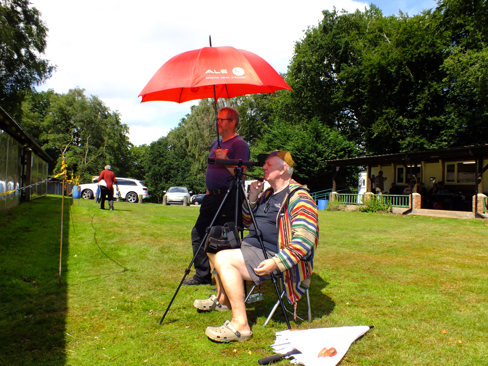 Photograph shows that there could be something "shady" going on here!  My mistake ... it's Paul Baron with his umbrella-come-parasol in hand, keeping the glare of the afternoon sun off the spotting scope of Lee Featherstone!